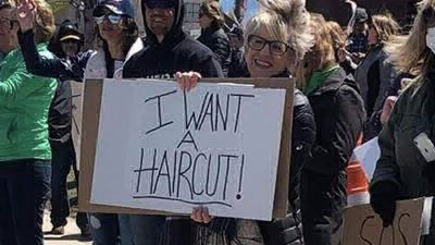 Protestors holding a sign about wanting a haircut